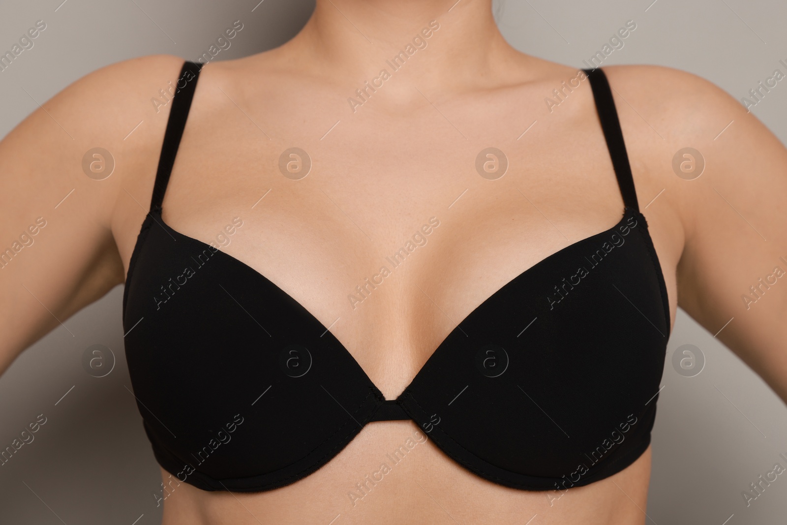 Photo of Woman wearing beautiful bra on light background, closeup