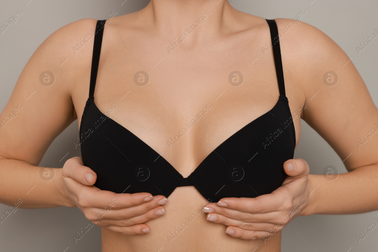 Photo of Woman wearing beautiful bra on light background, closeup