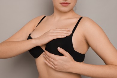 Photo of Woman wearing beautiful bra on light background, closeup