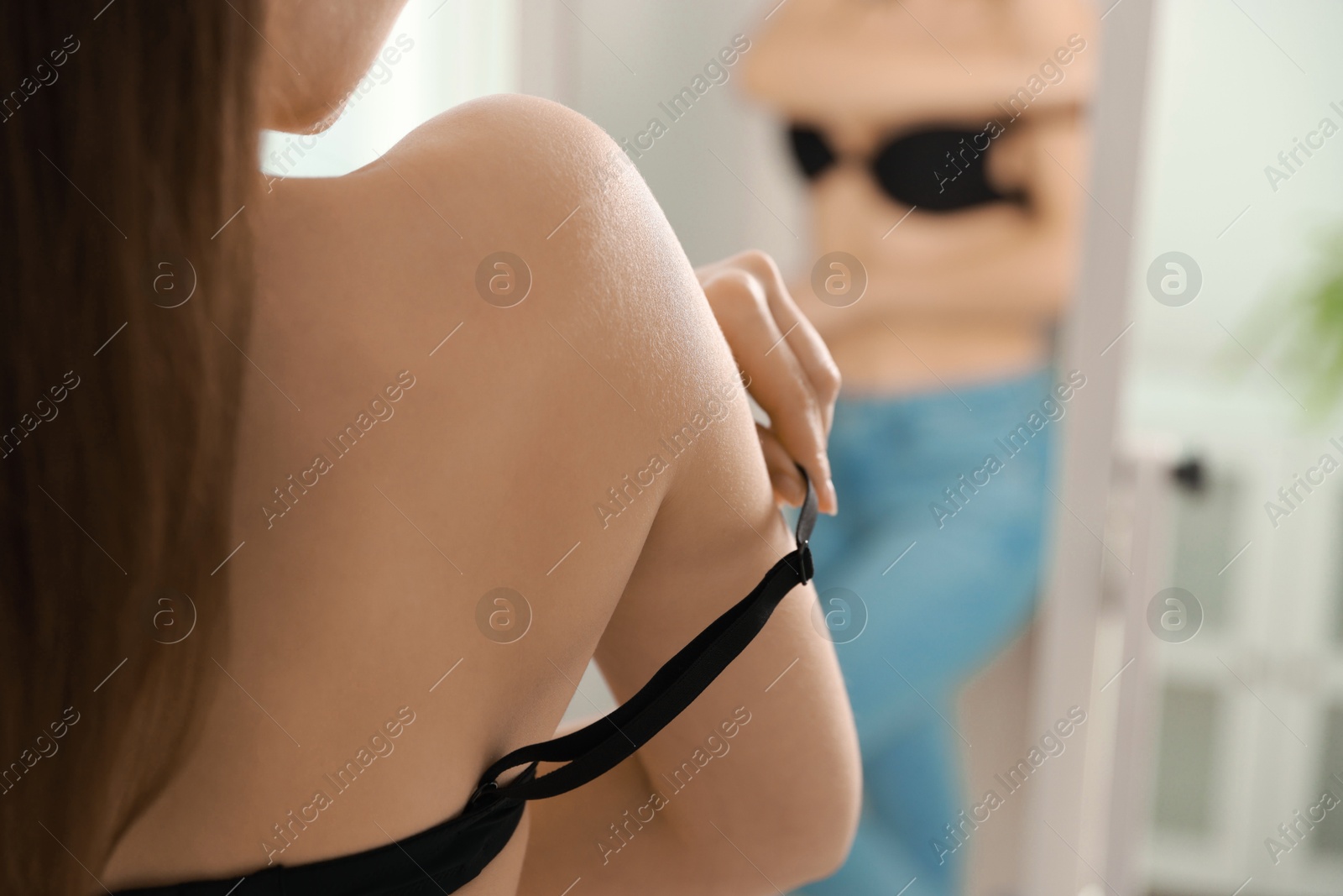 Photo of Woman adjusting strap of comfortable bra indoors, closeup