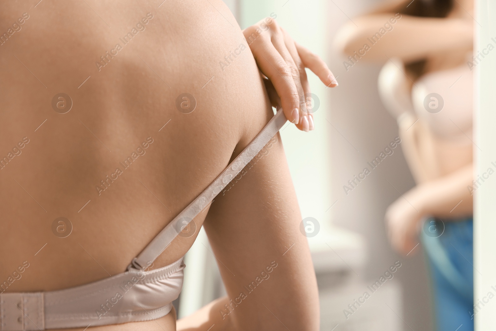 Photo of Woman adjusting strap of comfortable bra indoors, closeup