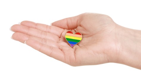 Photo of Woman with heart shaped pin in LGBT colors on white background, closeup