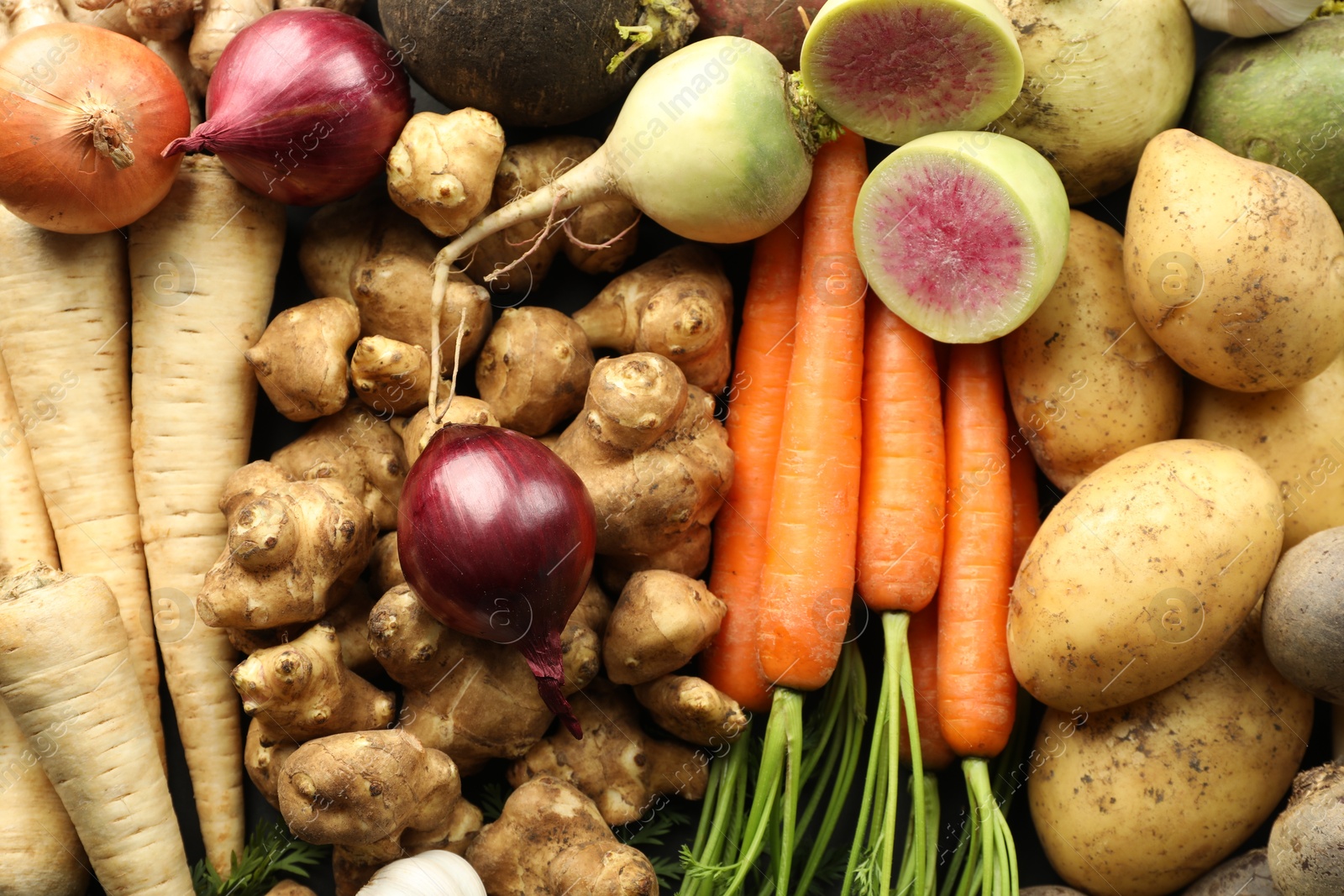 Photo of Different raw root vegetables as background, top view