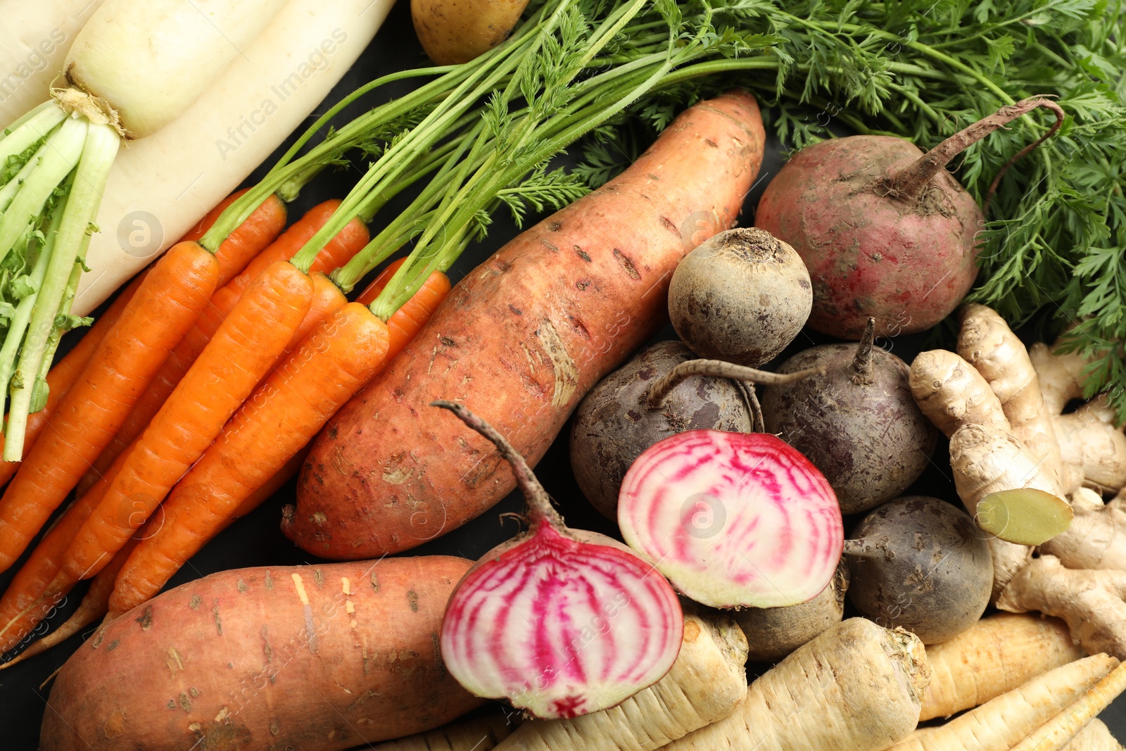 Photo of Different raw root vegetables as background, top view