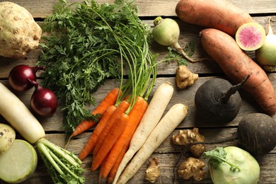 Photo of Different root vegetables on wooden table, flat lay