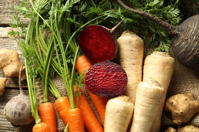 Photo of Different root vegetables on wooden table, flat lay