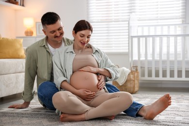 Photo of Pregnant woman and her husband on floor at home