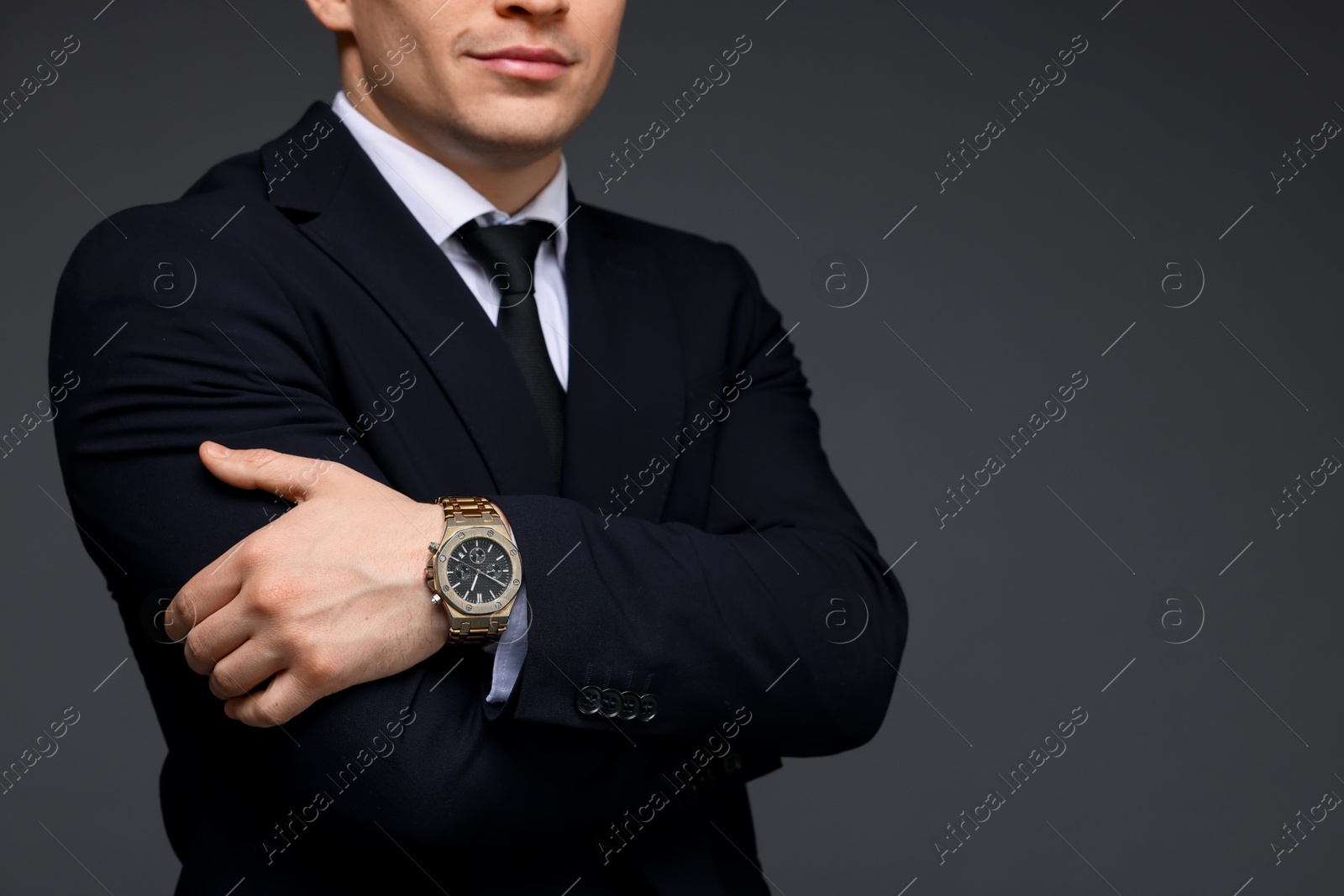 Photo of Man in classic suit with stylish watch on grey background, closeup. Space for text