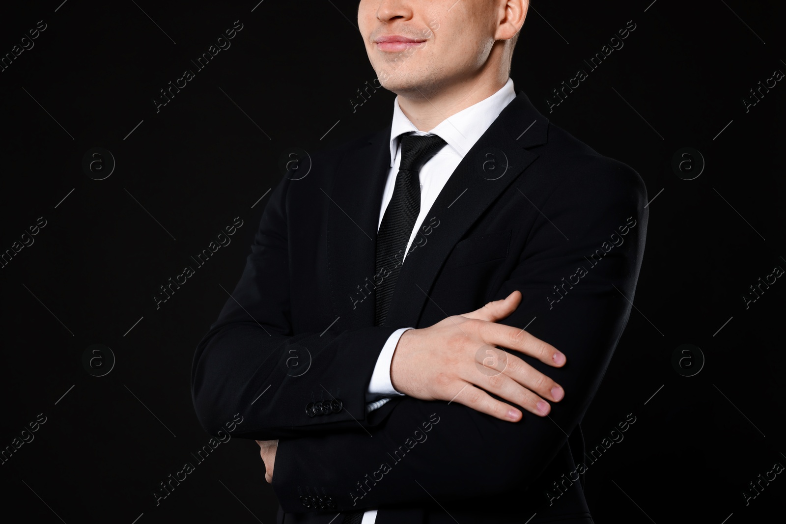 Photo of Man in classic suit on black background, closeup