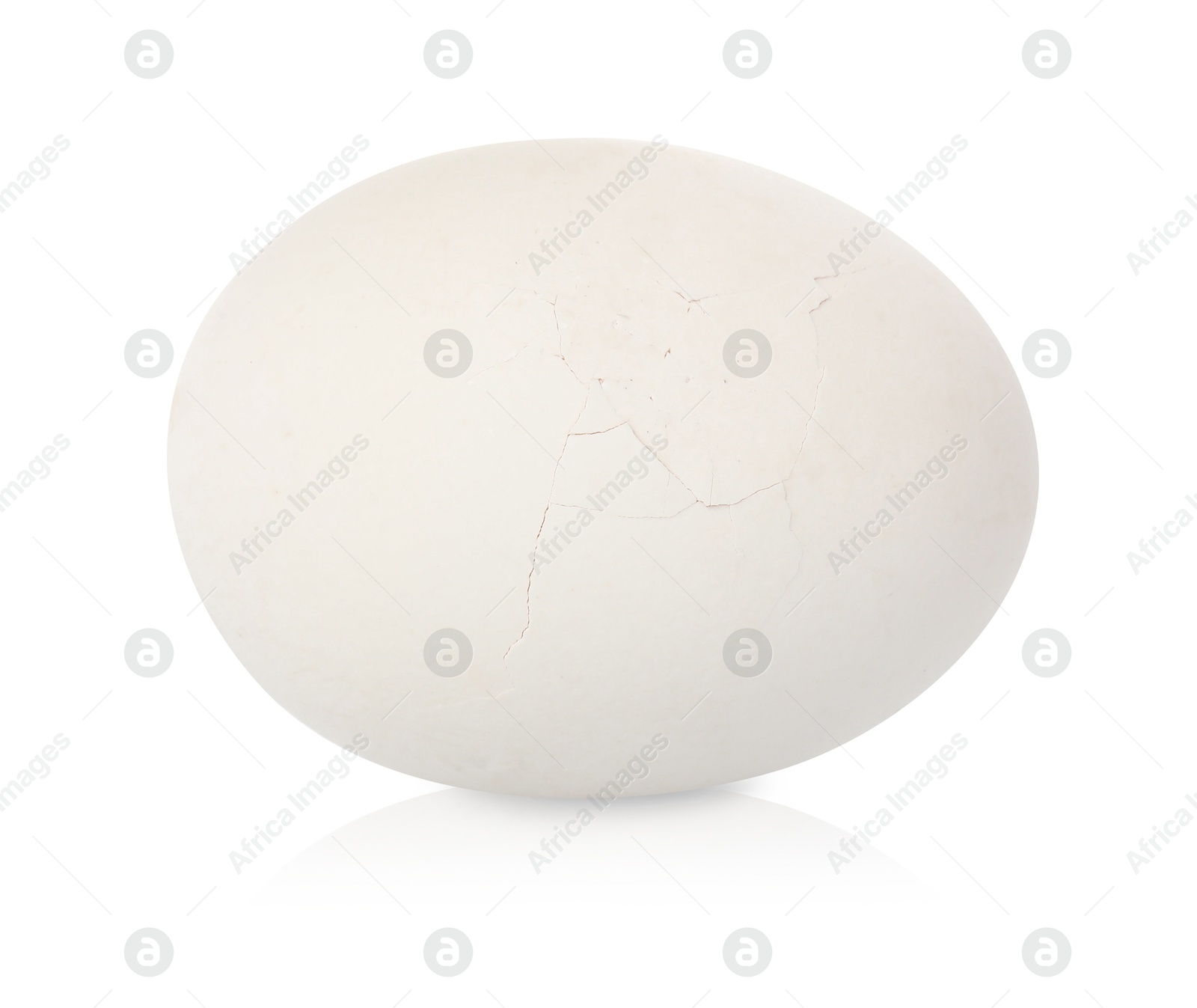 Photo of One piece of broken eggshell on mirror surface against white background