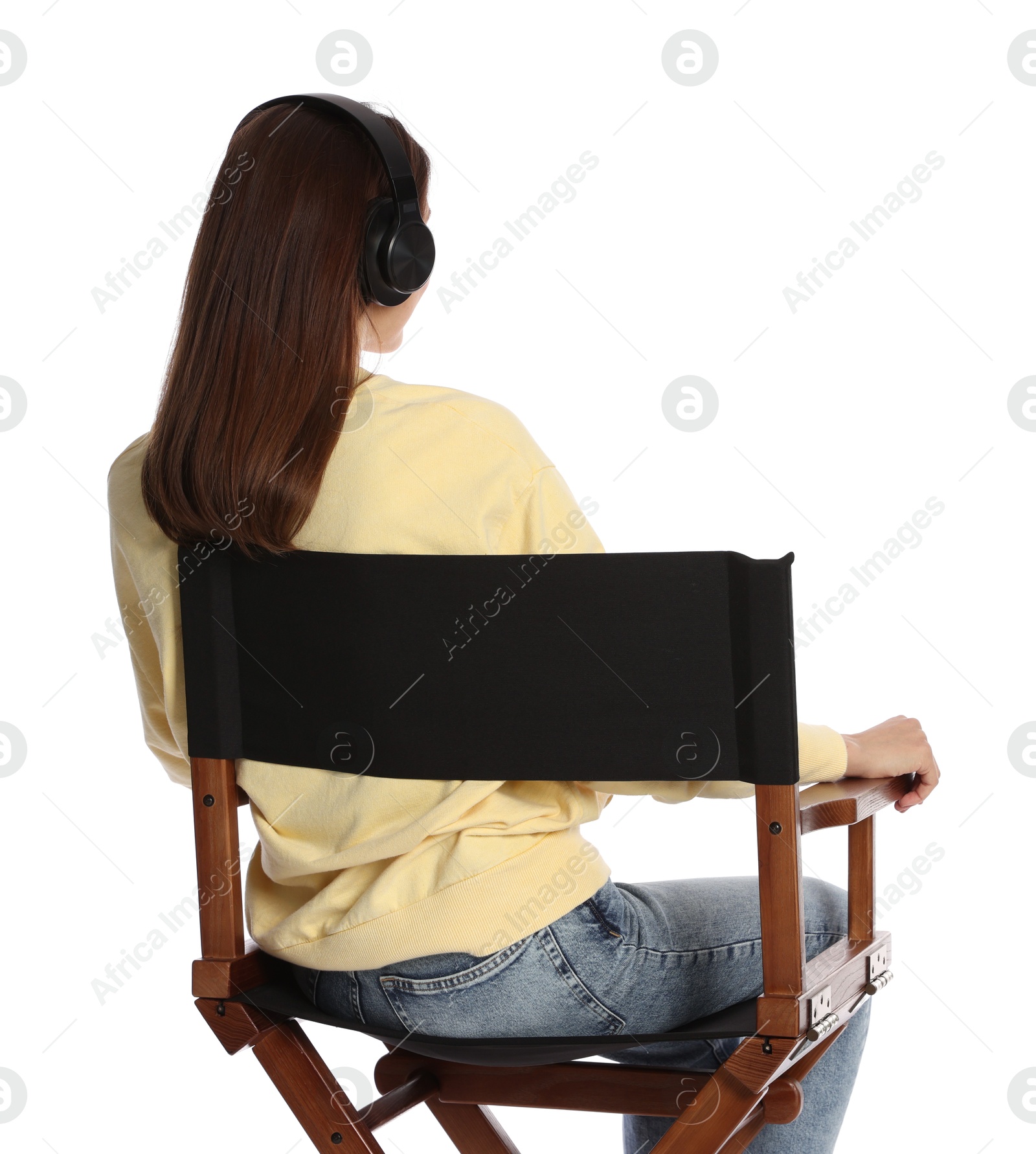 Photo of Woman with headset sitting in director's chair on white background, back view