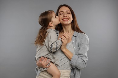 Photo of Happy mother with her cute little daughter on grey background