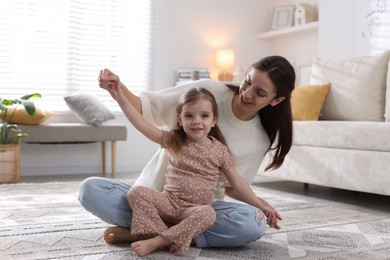 Photo of Happy mother having fun with her cute little daughter at home