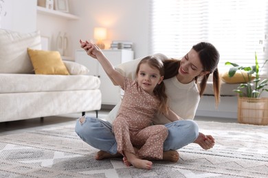 Photo of Happy mother having fun with her cute little daughter at home