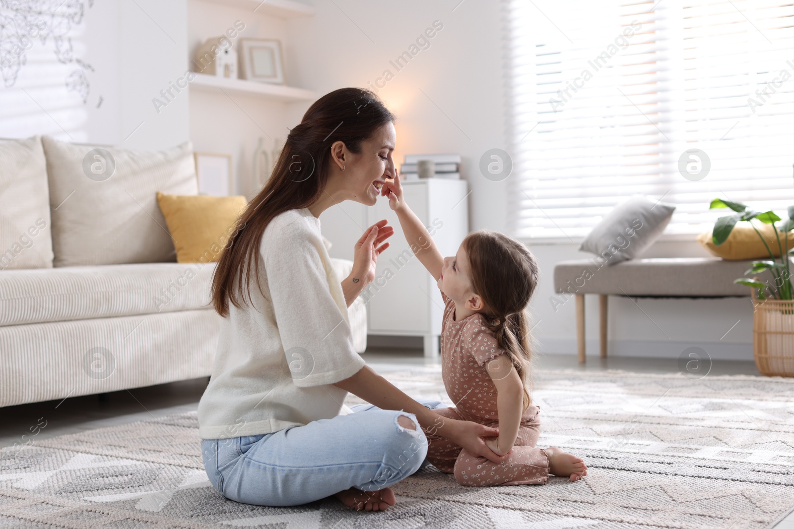 Photo of Happy mother having fun with her cute little daughter at home