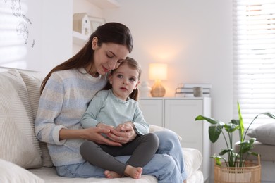 Photo of Beautiful mother with her cute little daughter on sofa at home