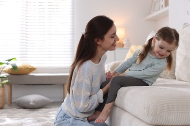 Happy mother with her cute little daughter at home