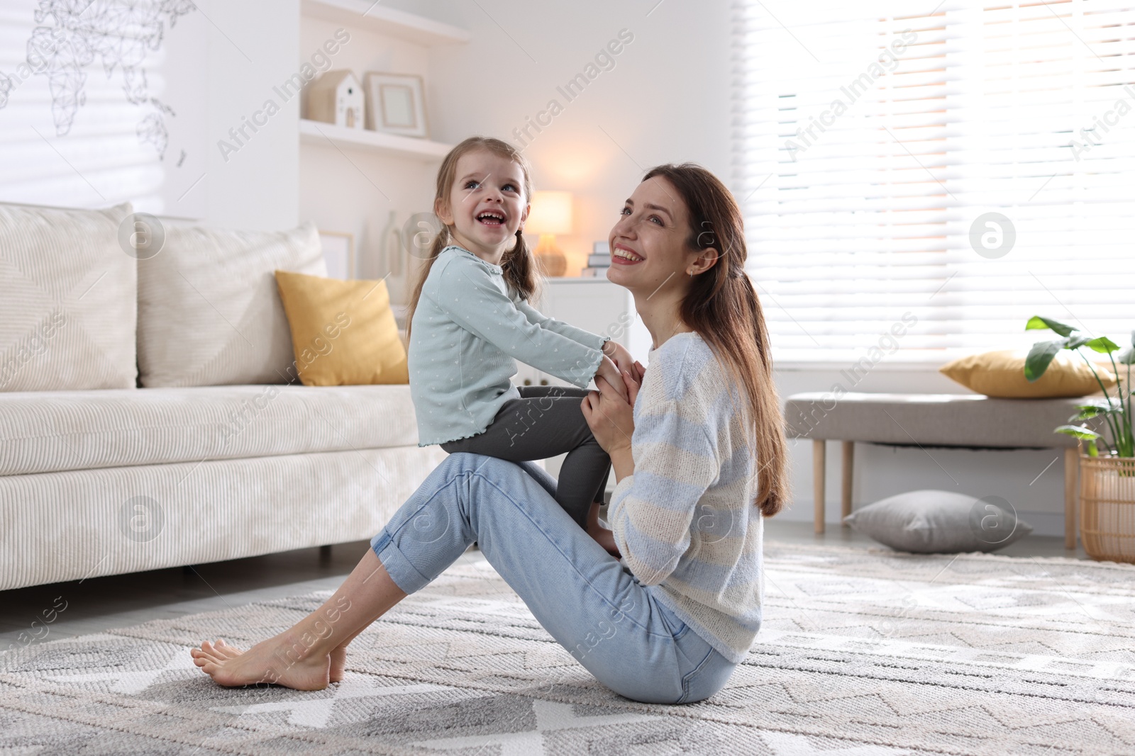 Photo of Happy mother having fun with her cute little daughter at home