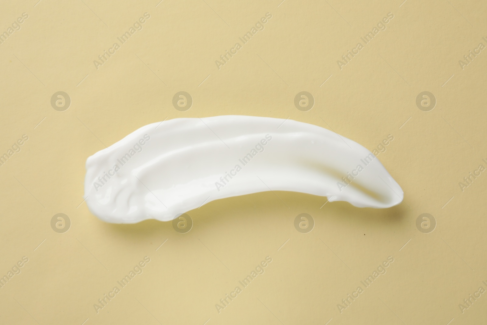 Photo of Smear of body cream on beige background, top view