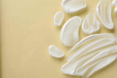 Photo of Smears of body cream on beige background, top view. Space for text