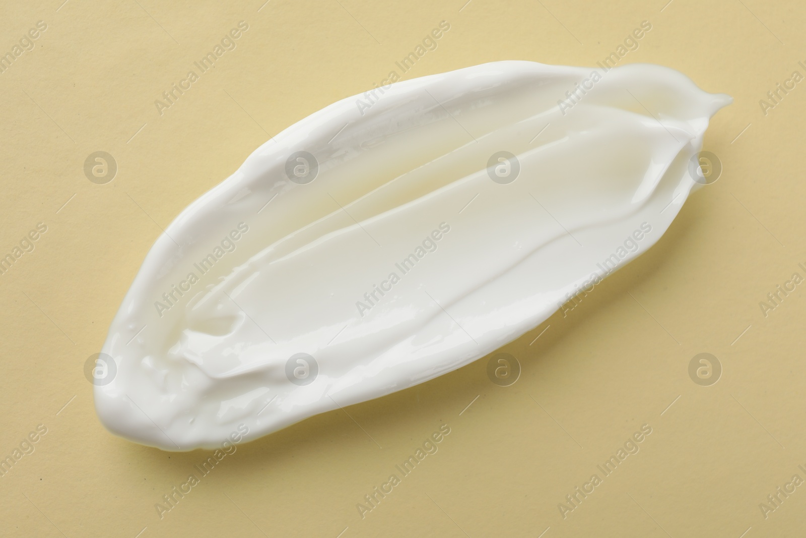 Photo of Smear of body cream on beige background, top view