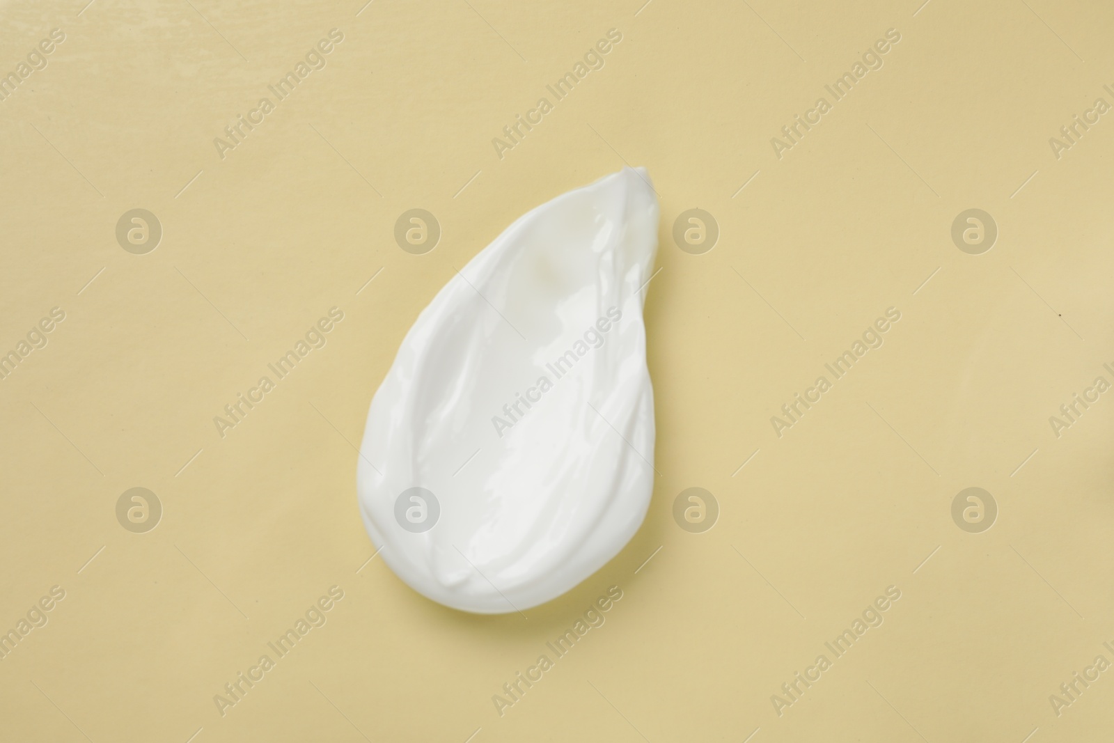 Photo of Smear of body cream on beige background, top view