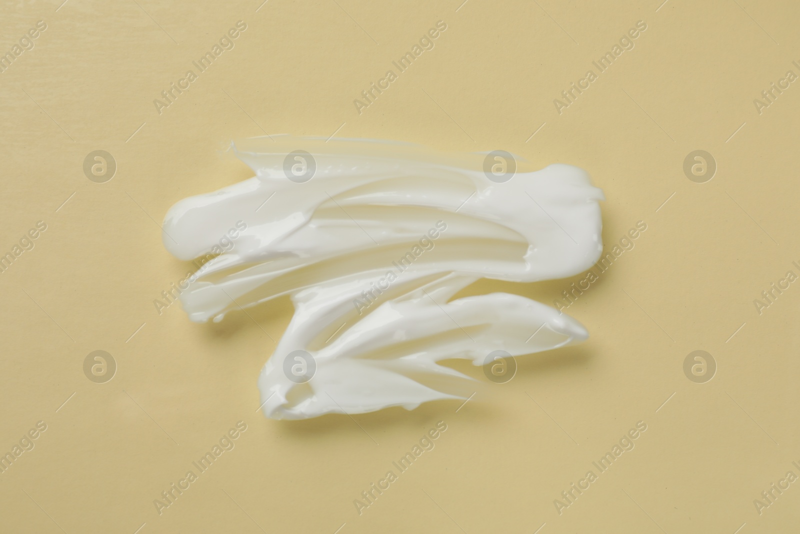 Photo of Smudge of body cream on beige background, top view