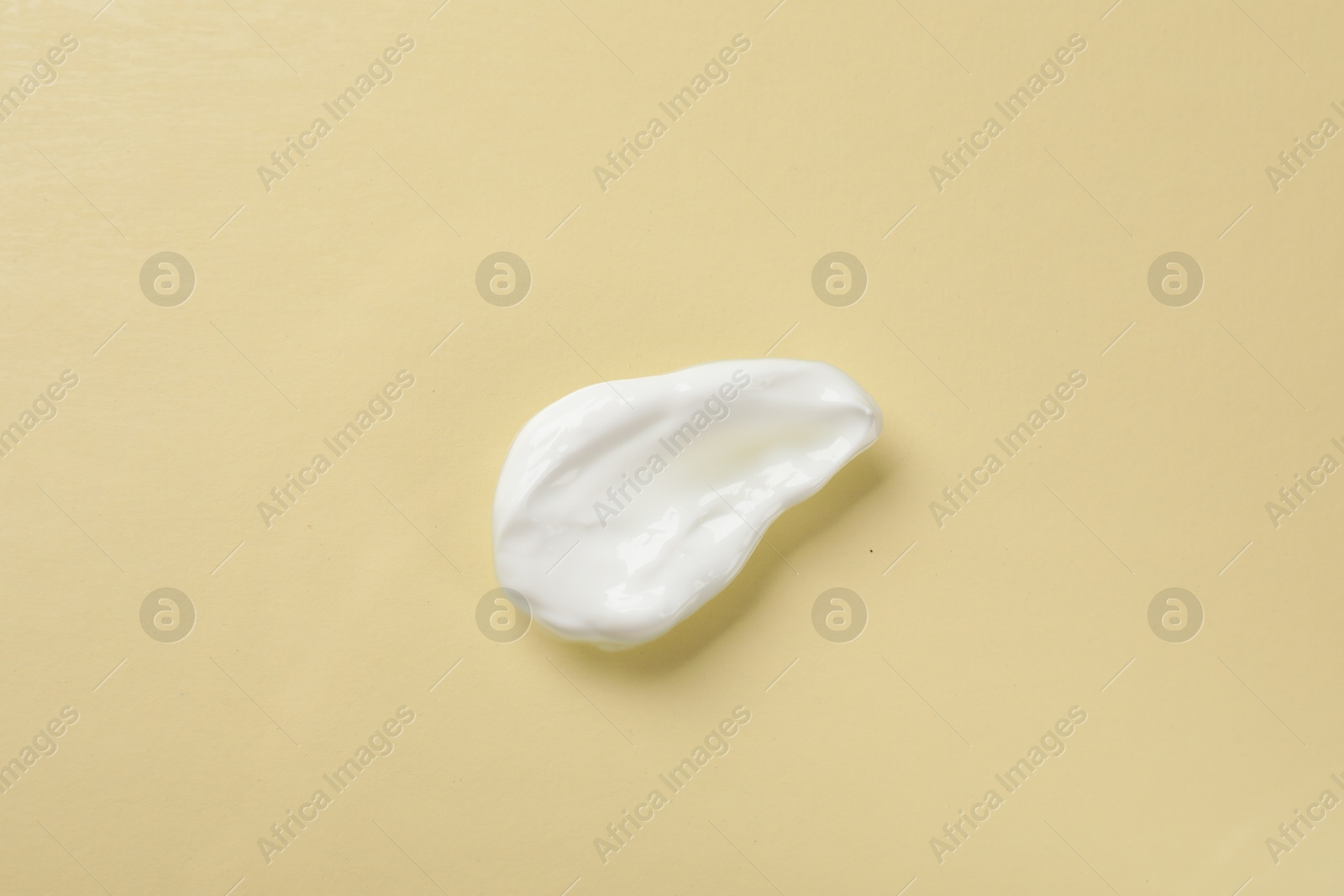 Photo of Smear of body cream on beige background, top view