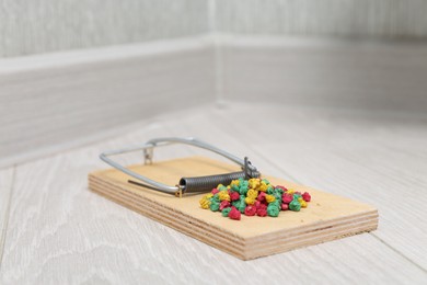 Photo of Mouse trap with rat poison on floor indoors, closeup