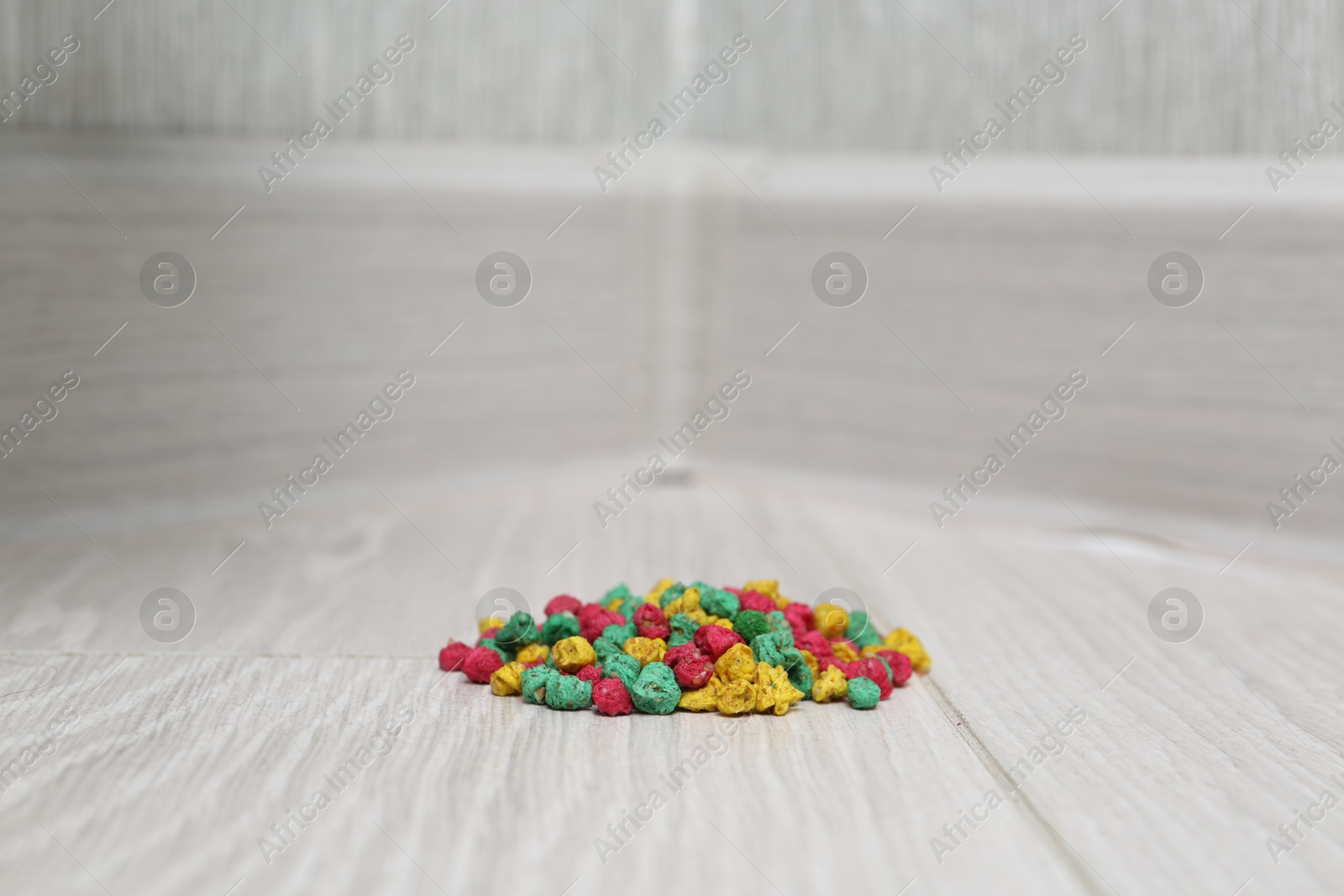 Photo of Pile of rat poison on floor indoors, closeup. Space for text