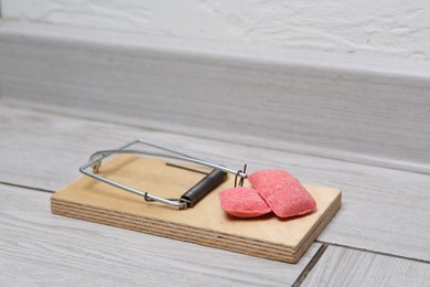 Photo of Mouse trap with rat poison on floor indoors, closeup