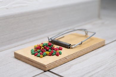 Photo of Mouse trap with rat poison on floor indoors, closeup