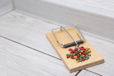 Photo of Mouse trap with rat poison on floor indoors, closeup. Space for text