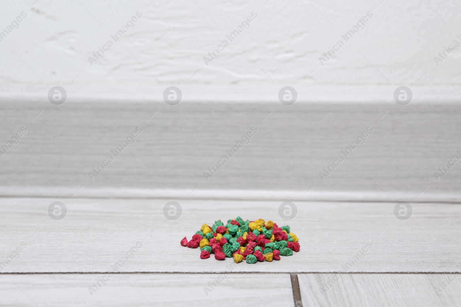 Photo of Pile of rat poison on floor indoors, space for text