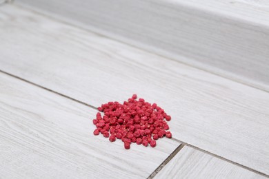 Photo of Pile of rat poison on floor indoors, closeup