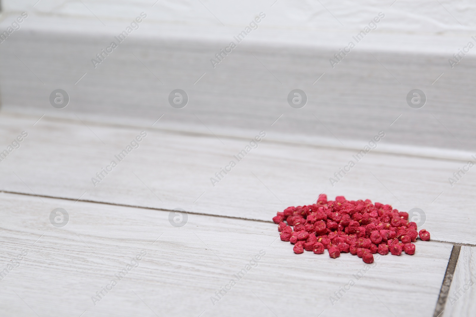 Photo of Pile of rat poison on floor indoors, space for text