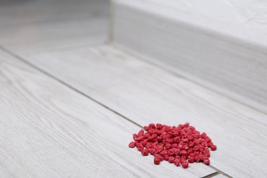 Photo of Pile of rat poison on floor indoors, closeup. Space for text