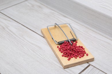 Photo of Mouse trap with rat poison on floor indoors, closeup. Space for text