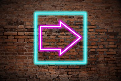 Image of Neon pointer with arrow on brick wall