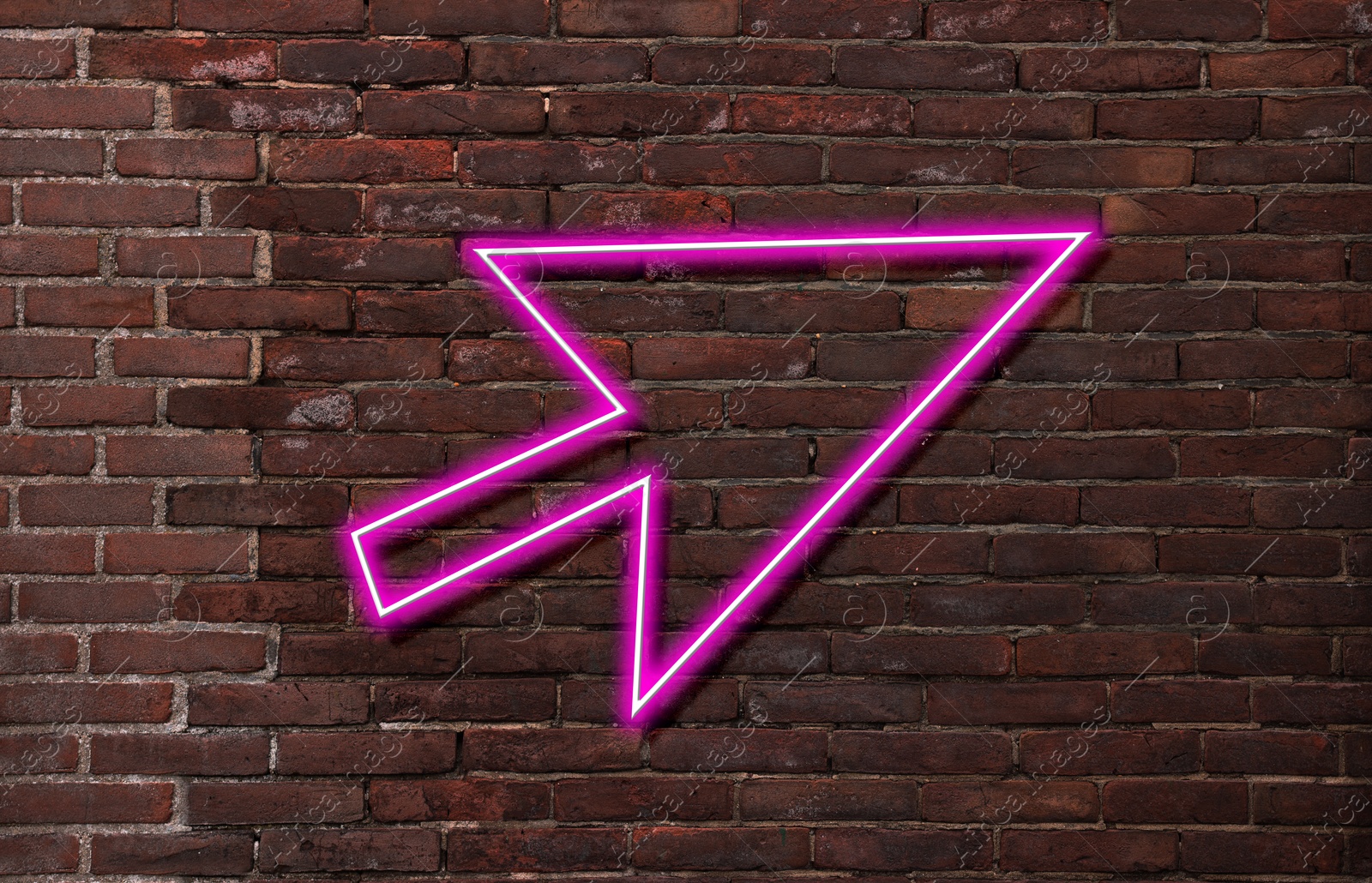 Image of Pink neon arrow-shaped pointer on brick wall