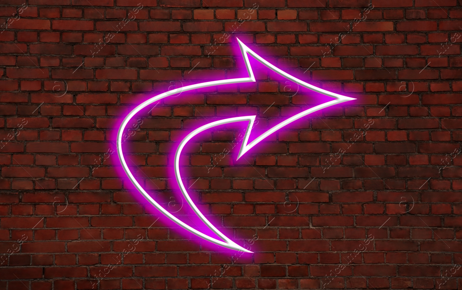 Image of Pink neon arrow-shaped pointer on brick wall