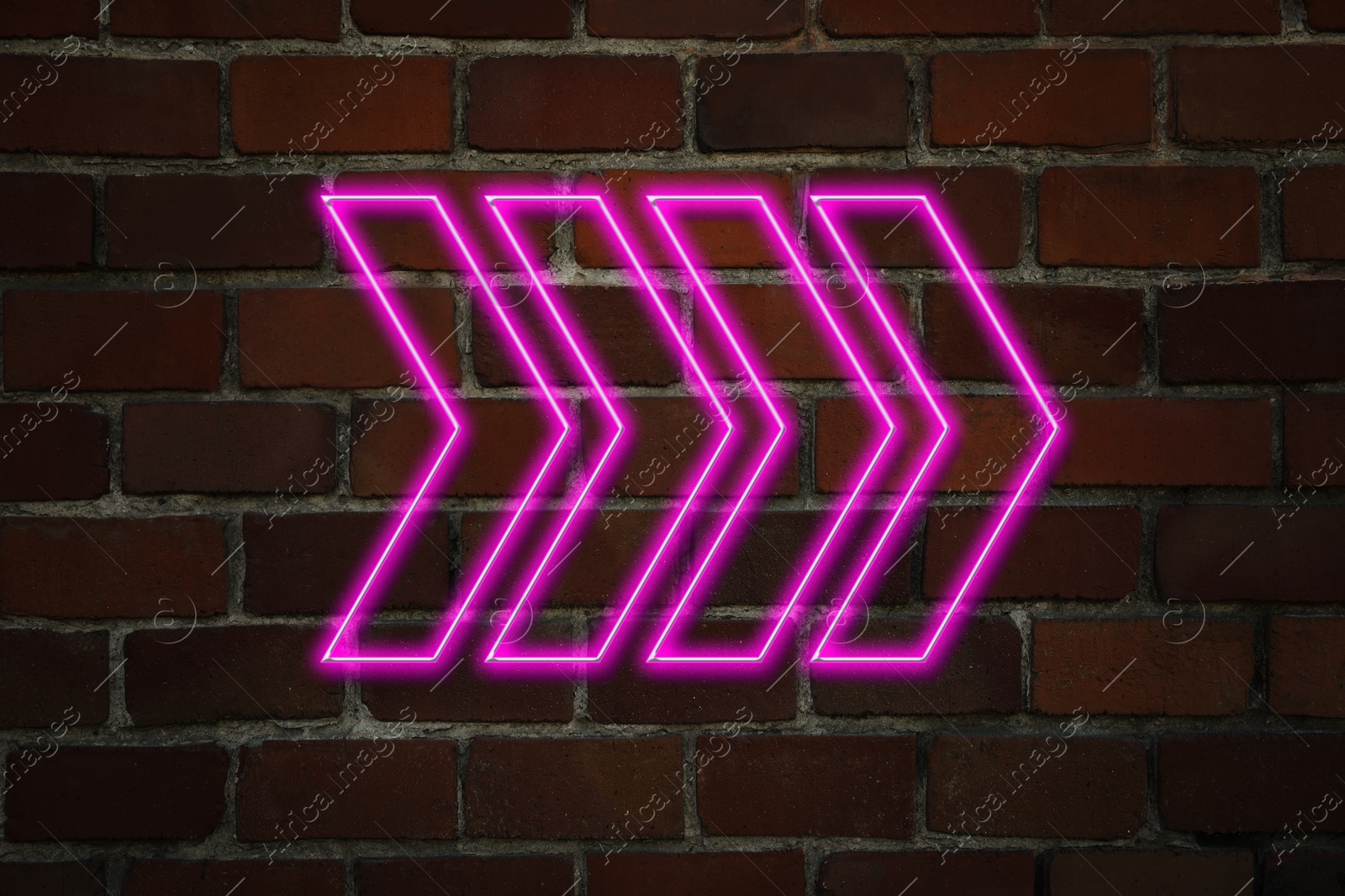 Image of Pink neon arrow-shaped pointer on brick wall