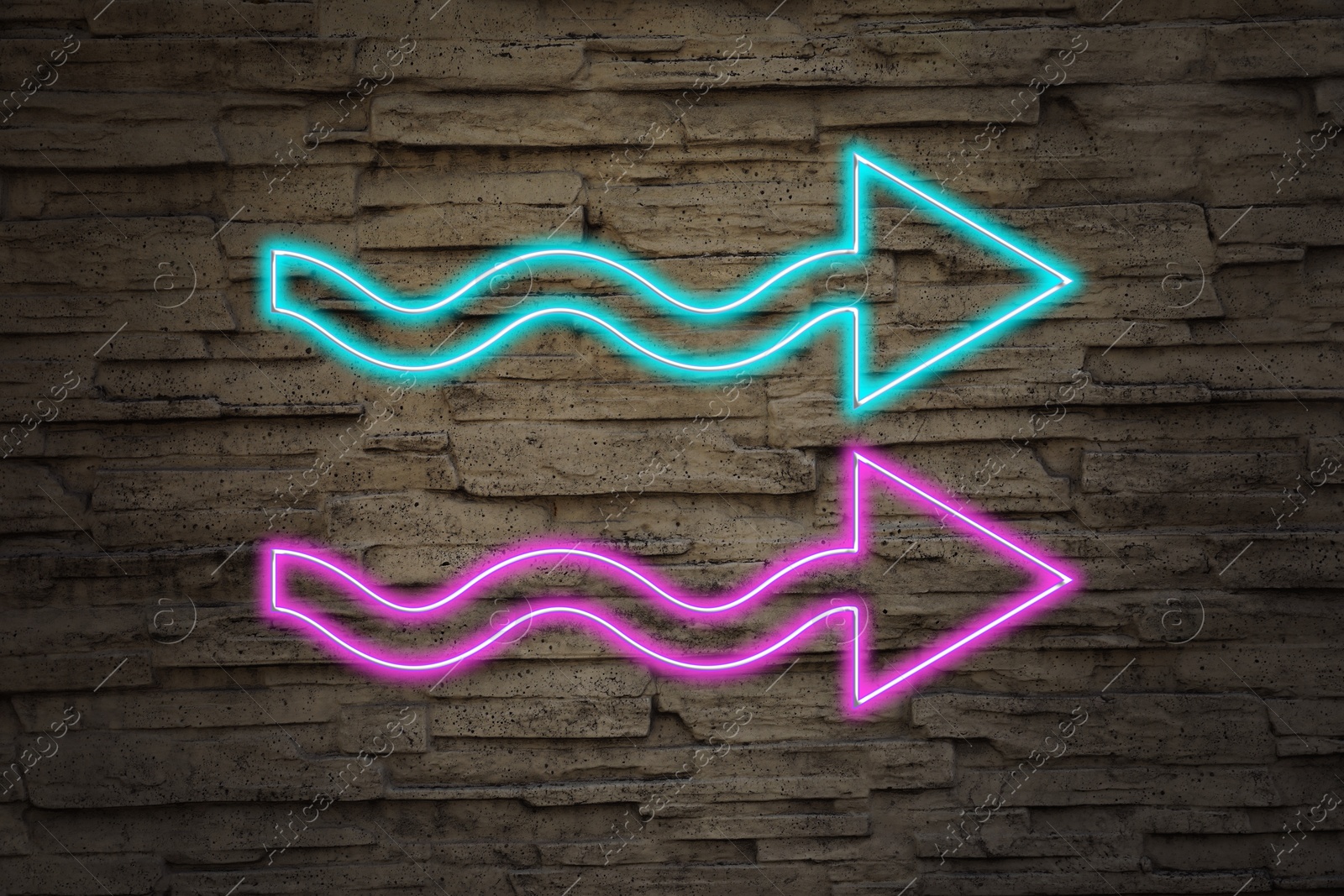 Image of Bright neon arrow-shaped pointer on stone wall