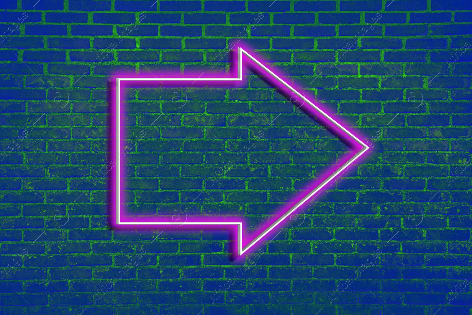 Image of Pink neon arrow-shaped pointer on blue brick wall