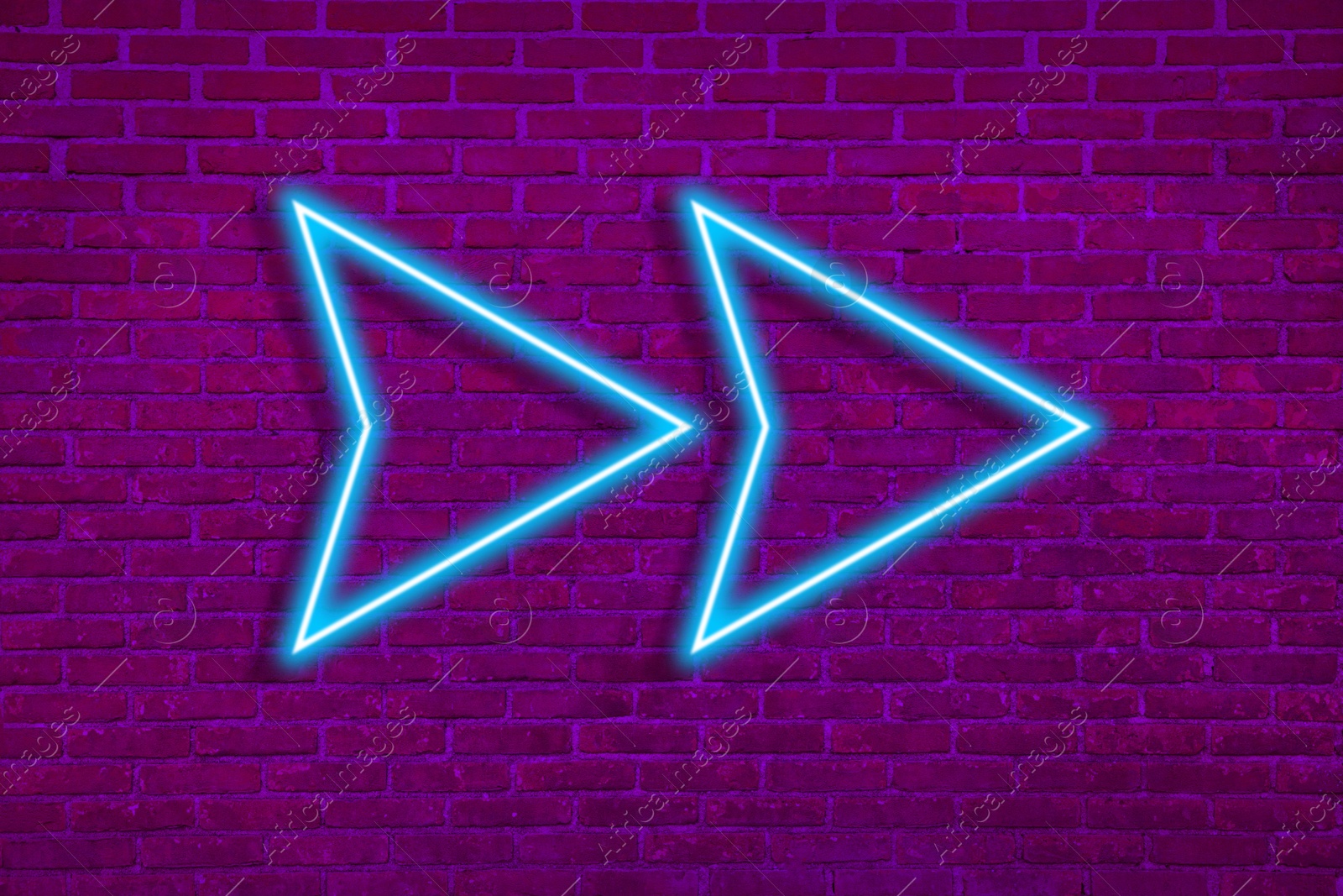 Image of Bright neon arrow-shaped pointer on brick wall