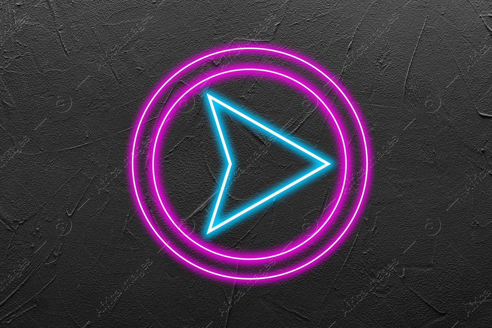 Image of Neon pointer with arrow on grey textured wall