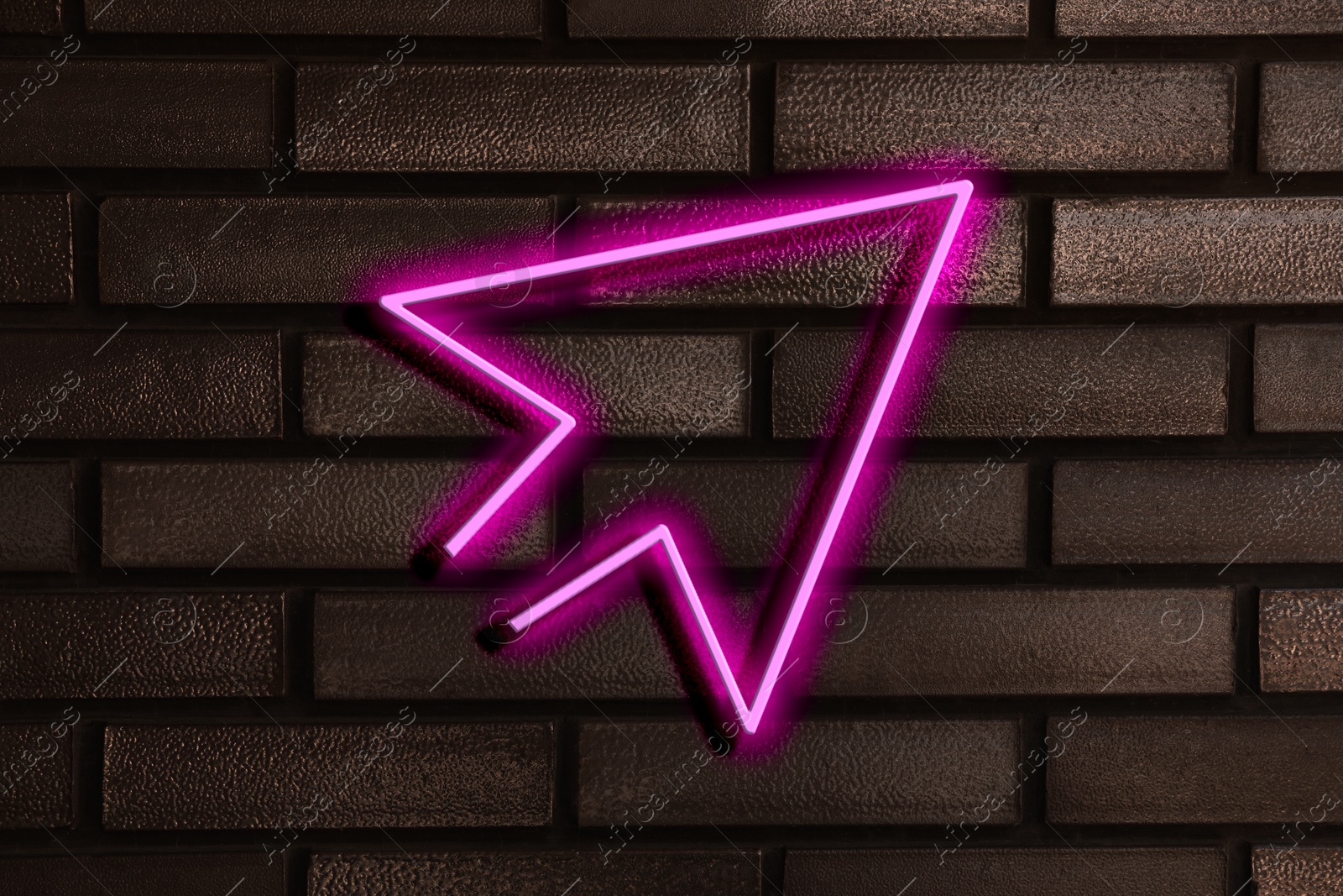 Image of Pink neon arrow-shaped pointer on brick wall