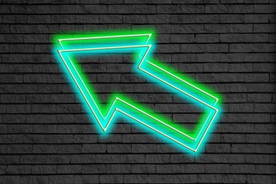 Image of Bright neon arrow-shaped pointer on brick wall