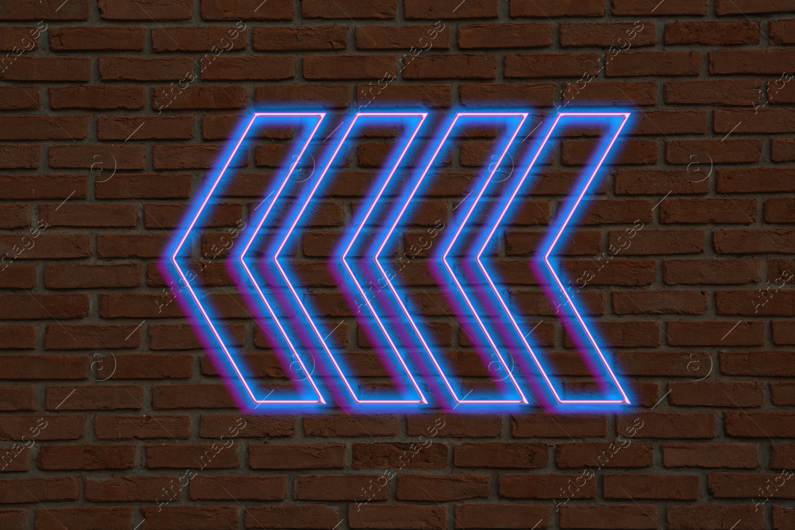 Image of Bright neon arrow-shaped pointer on brick wall