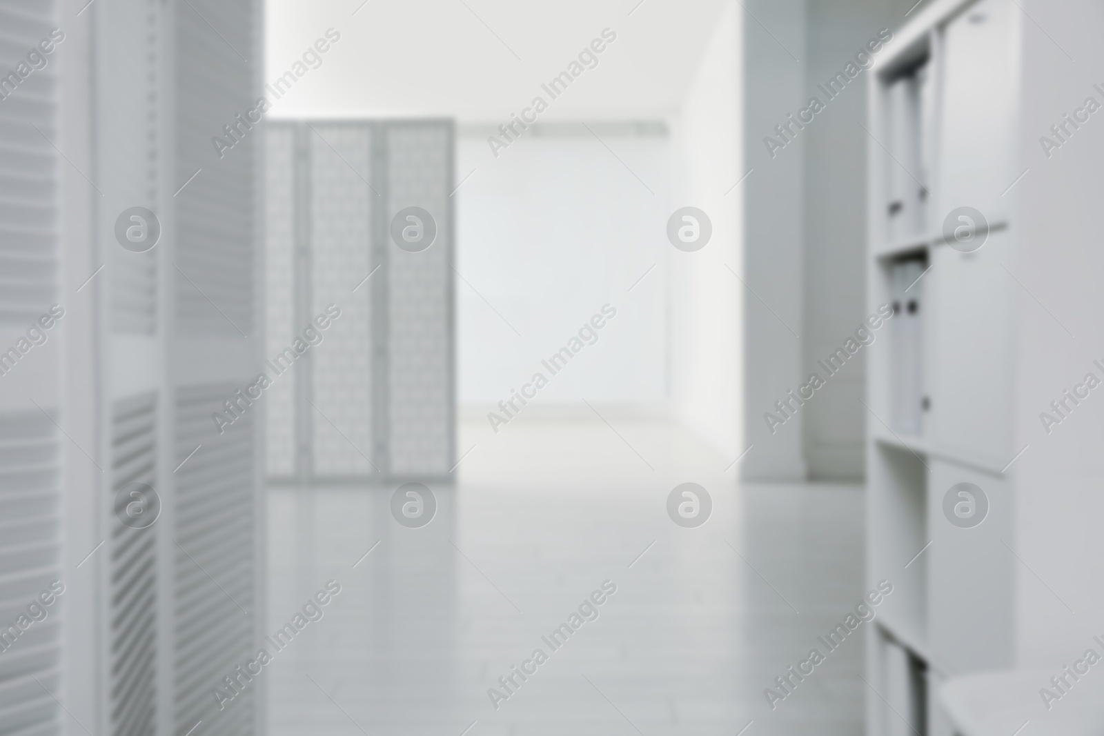 Image of Blurred view of empty office corridor with furniture